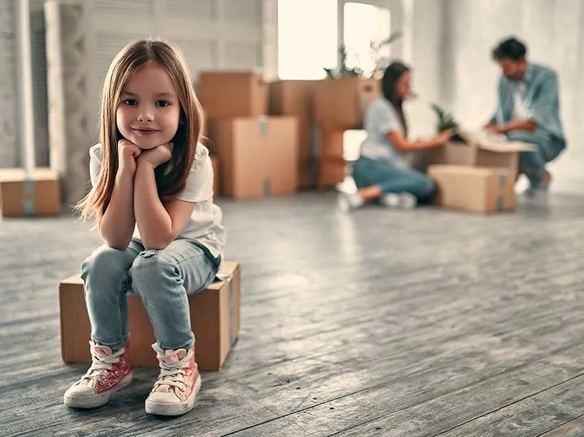 Family waiting in a empty house and boxes for movers to arrive with their belongings.